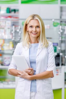 pharmacist with digital tablet in drugstore clipart