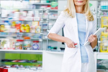 pharmacist with digital tablet in drugstore clipart