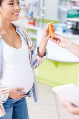 pharmacist giving pills to pregnant woman clipart