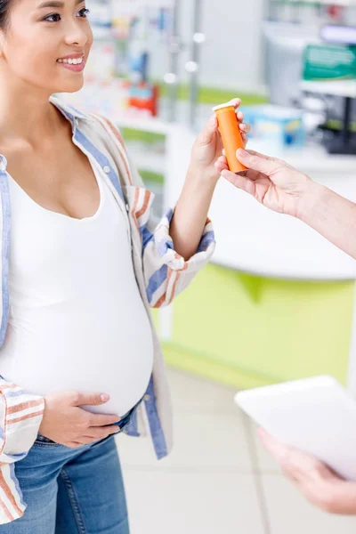 Farmacêutico dando pílulas para mulher grávida — Fotografia de Stock