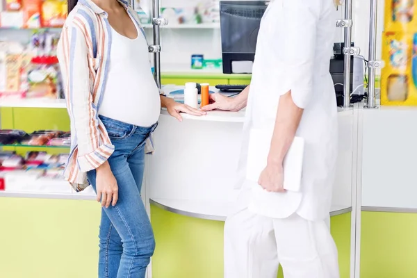 Apotheker geven pillen aan zwangere vrouw — Stockfoto