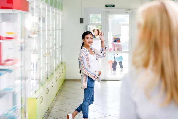 Pharmacist and pregnant woman in drugstore — Stock Photo, Image