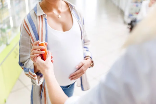Pharmacist giving pills to pregnant woman — Stock Photo, Image