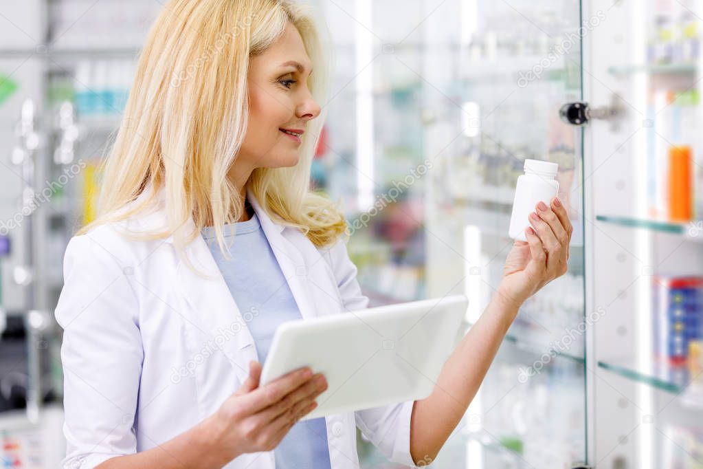 pharmacist with digital tablet and medication