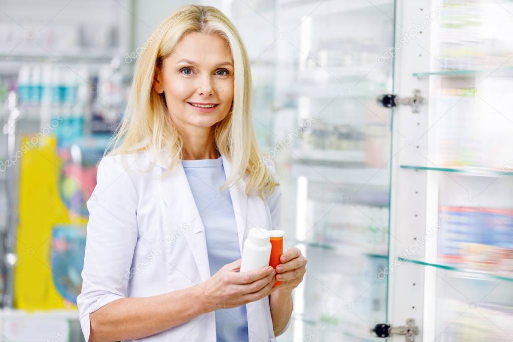 pharmacist holding containers with medications