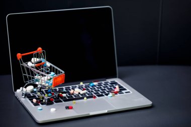dizüstü bilgisayar ve küçük alışveriş arabası hap