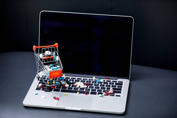 laptop and pills in small shopping trolley