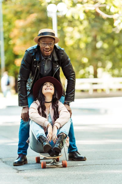 Flickvän som sitter på longboard — Stockfoto