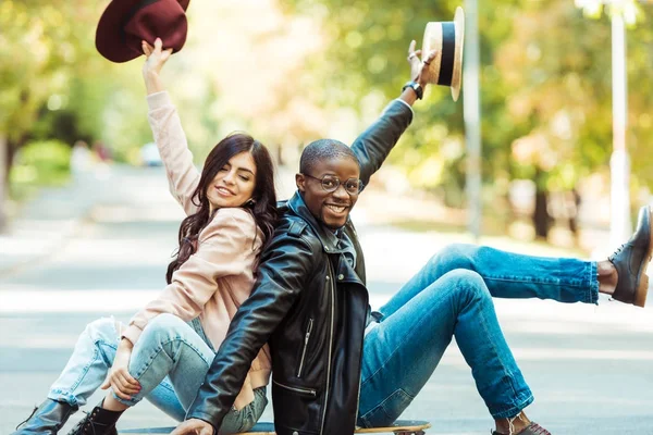 Paar sitzt mit Hüten in der Hand auf Longboard — Stockfoto