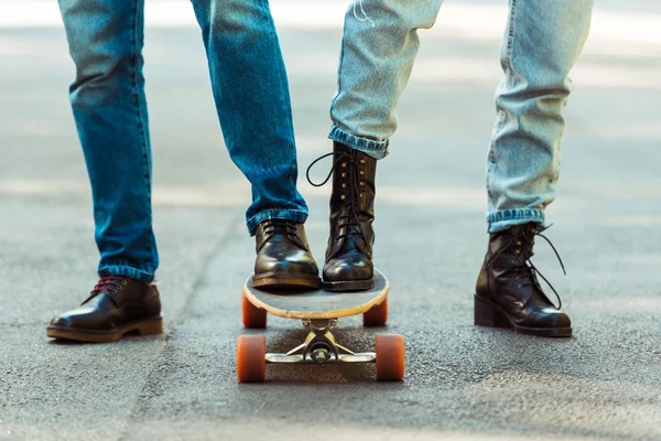 Couple standing together on one longboard — Stock Photo, Image