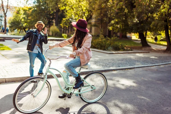 Novia montando en bicicleta y novio haciendo muecas — Foto de stock gratis