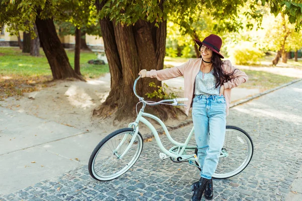 Woman in hat standing with bicycle — Free Stock Photo