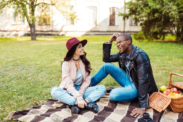 Interracial couple sitting in park — Stock Photo, Image