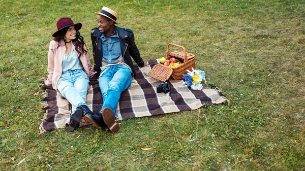 Pareja multicultural sentada en manta — Foto de Stock