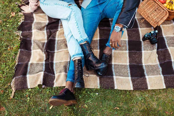 Multicultural couple sitting on blanket — Stock Photo, Image