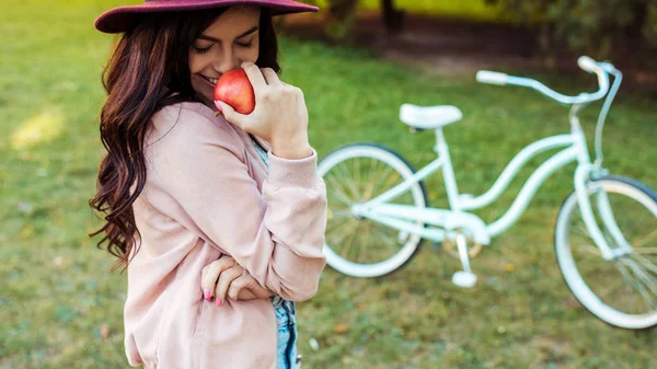 Žena v klobouku drží červené jablko — Stock fotografie