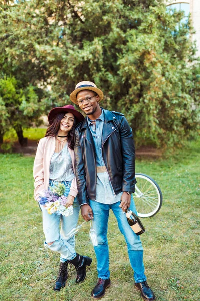 Couple standing with flowers and champagne — Stock Photo, Image