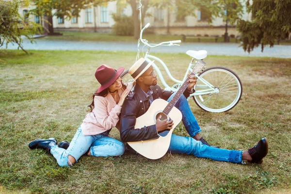 Парень играет на гитаре для девушки — стоковое фото