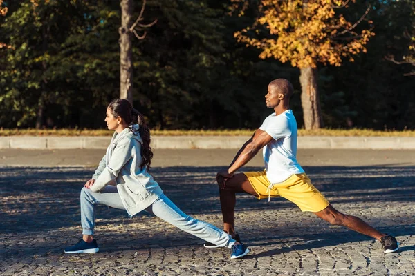 Couple stretching on road — Stock Photo, Image