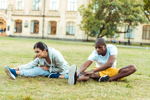 Paar stretching op gras — Stockfoto