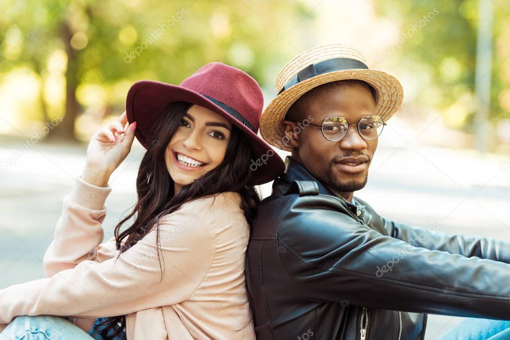 couple in hats sitting back to back