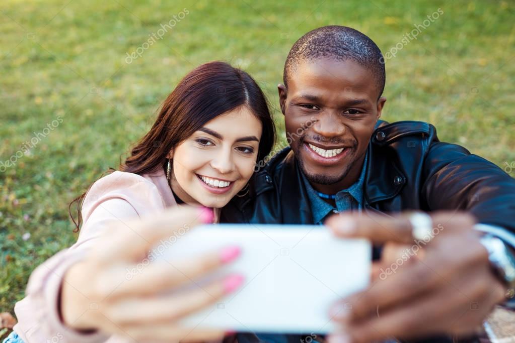 multicultural couple taking selfie 