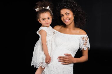 Pregnant woman holding small daughter clipart