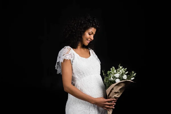 Kobieta w ciąży, trzymając bukiet kwiatów — Darmowe zdjęcie stockowe