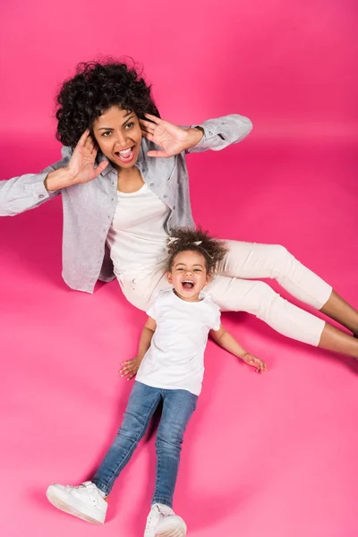 Mother and daughter screaming and sitting on floor — Stock Photo, Image