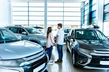 couple standing face to face in showroom clipart