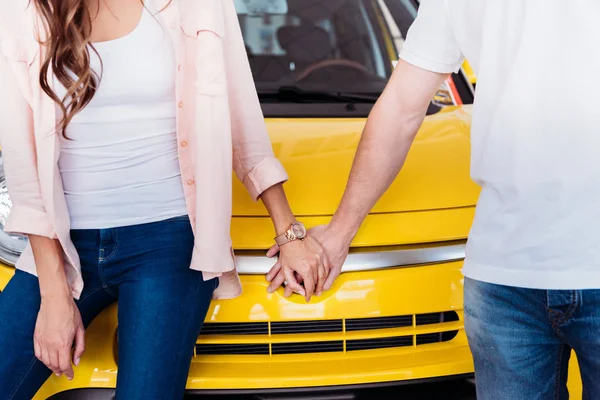 Casal de mãos dadas na frente do carro — Fotografia de Stock