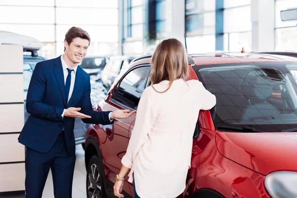 Manager inviting customer sit into car — Stock Photo, Image