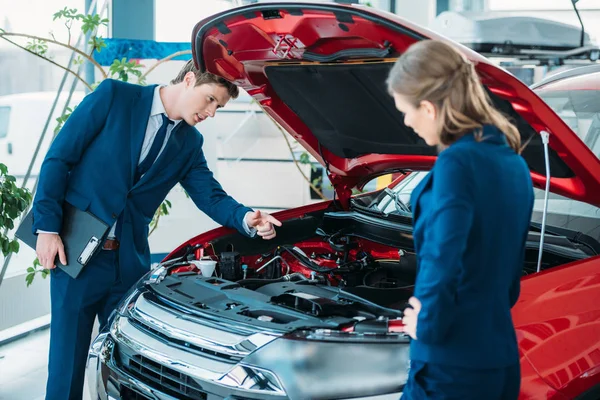 Managers looking under car hood — Stock Photo, Image