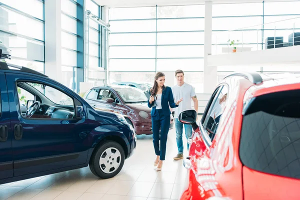 Verkaufsleiter zeigt Auto dem Kunden lizenzfreie Stockbilder