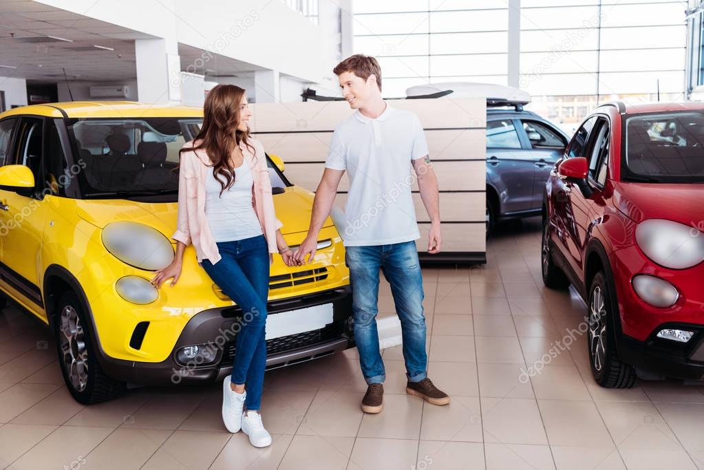 couple holding hands in front of car 