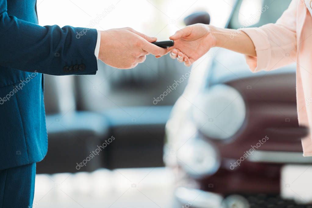 manager giving car key to customer