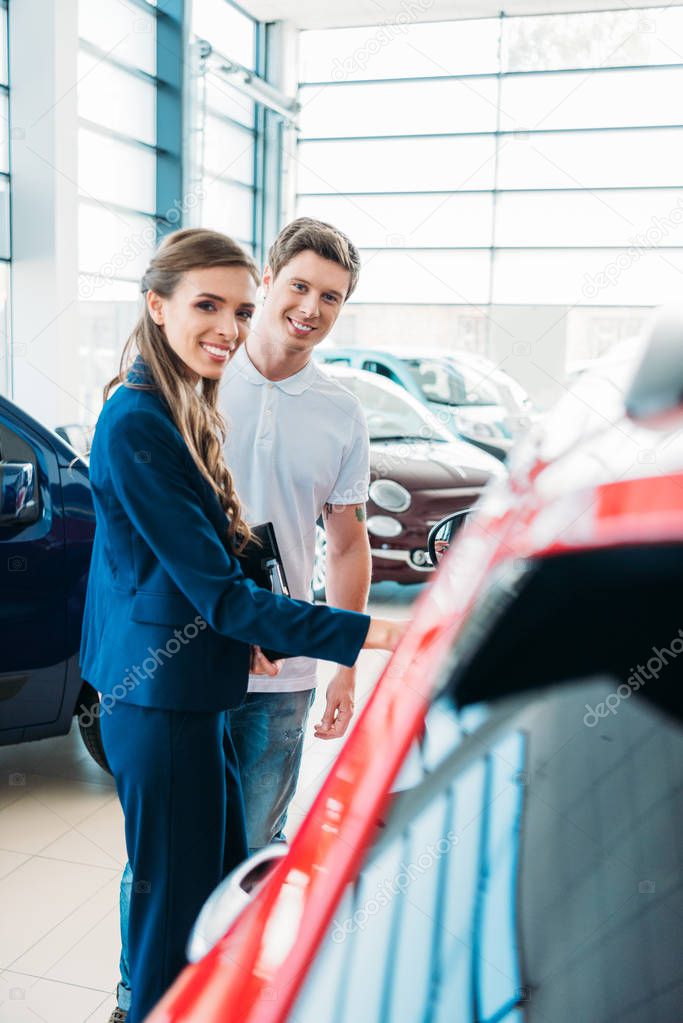 sales manager showing car to customer 