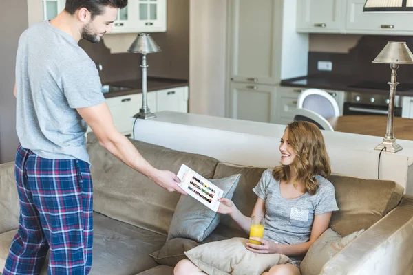 Hombre mostrando tableta a su novia — Foto de Stock