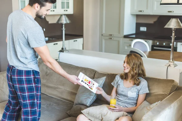 Hombre mostrando tableta a su novia — Foto de Stock