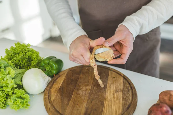 Mannen som skivning potatis — Stockfoto