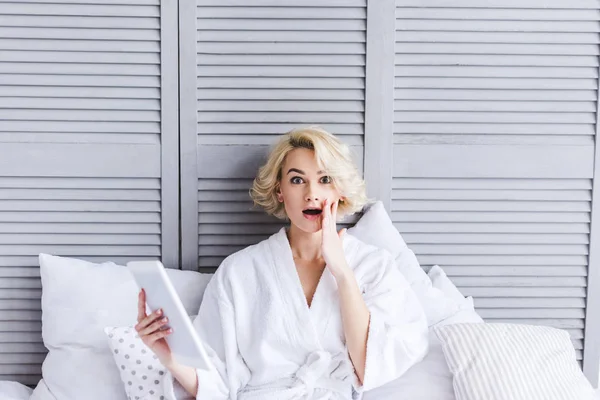 Shocked Young Woman Bathrobe Holding Digital Tablet Looking Camera Bedroom — Stock Photo, Image