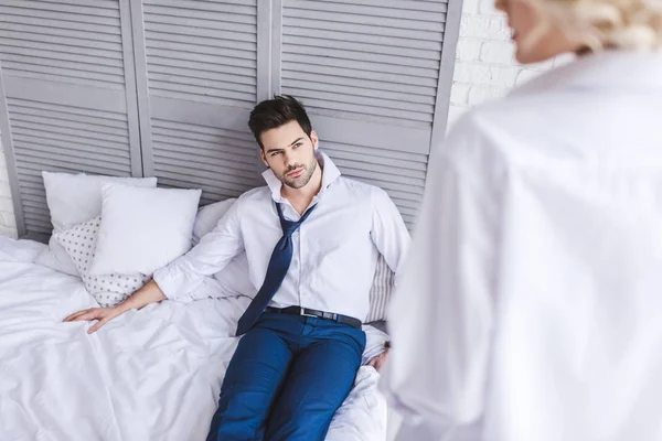 英俊男人的选择焦点躺在床上 看着女朋友 — 图库照片