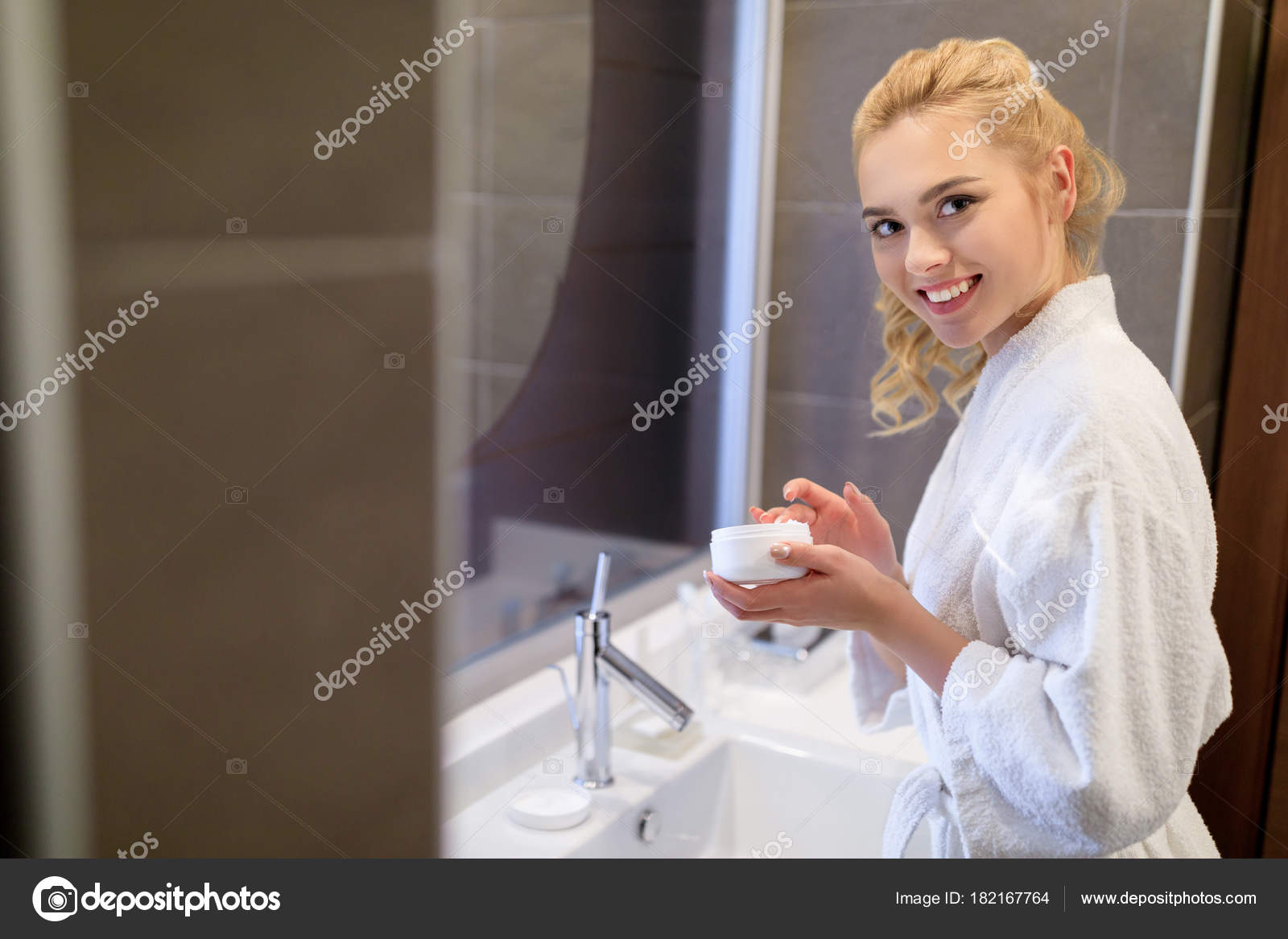 Lächelndes Mädchen Halten Gesichtscreme Und Blick Die Kamera ... Lächelndes Mädchen Halten Gesichtscreme Und Blick Die Kamera ...