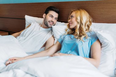 yatakta ve birbirine bakarak heteroseksüel çift ellerimi