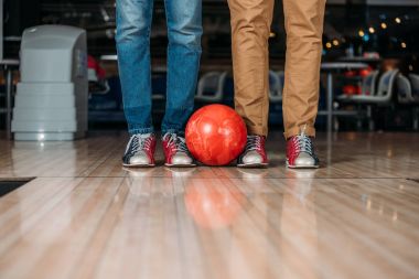 cropped shot of men standing in front of bowling alley with ball clipart