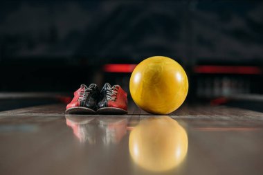 Sarı bowling topu kulüp sokak üzerinde ayakkabı ile