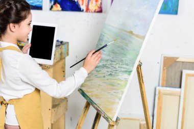 Resim ve Sanat Okulu atölyede tablet kullanarak çocuk yan görünüm