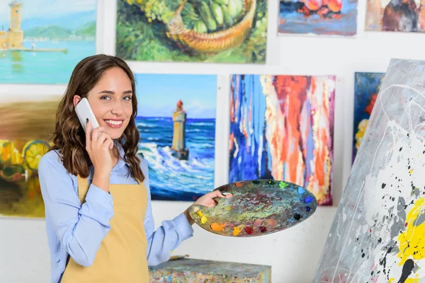 Vackra Kvinnliga Artist Talar Smartphone Verkstad Och Hålla Palett — Stockfoto