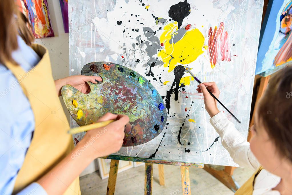 cropped image of pupil painting on lesson in workshop of art school