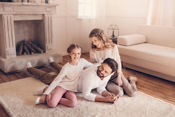 Glückliche junge Familie mit einem Kind, das Zeit miteinander zu Hause verbringt — Stockfoto